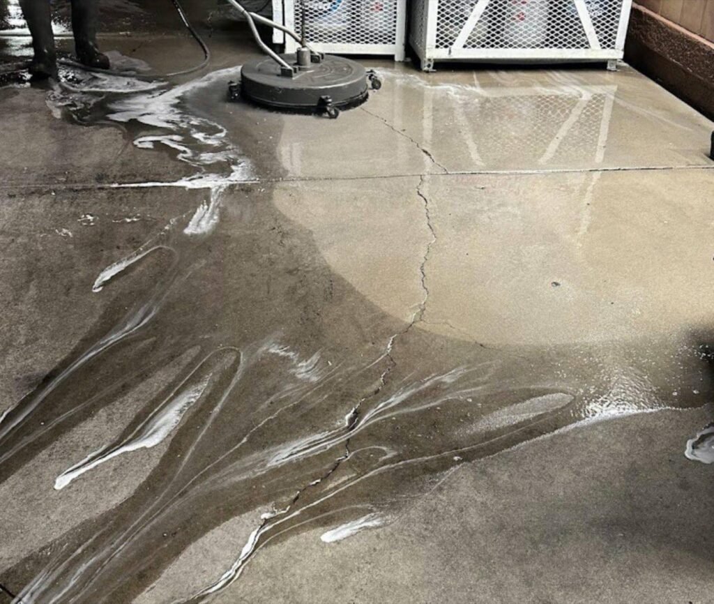 Commercial concrete mid-clean with detergent and a visible clean line