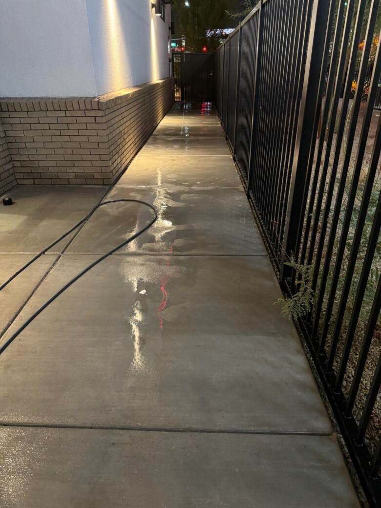 Clean commercial walkway alongside a building at night