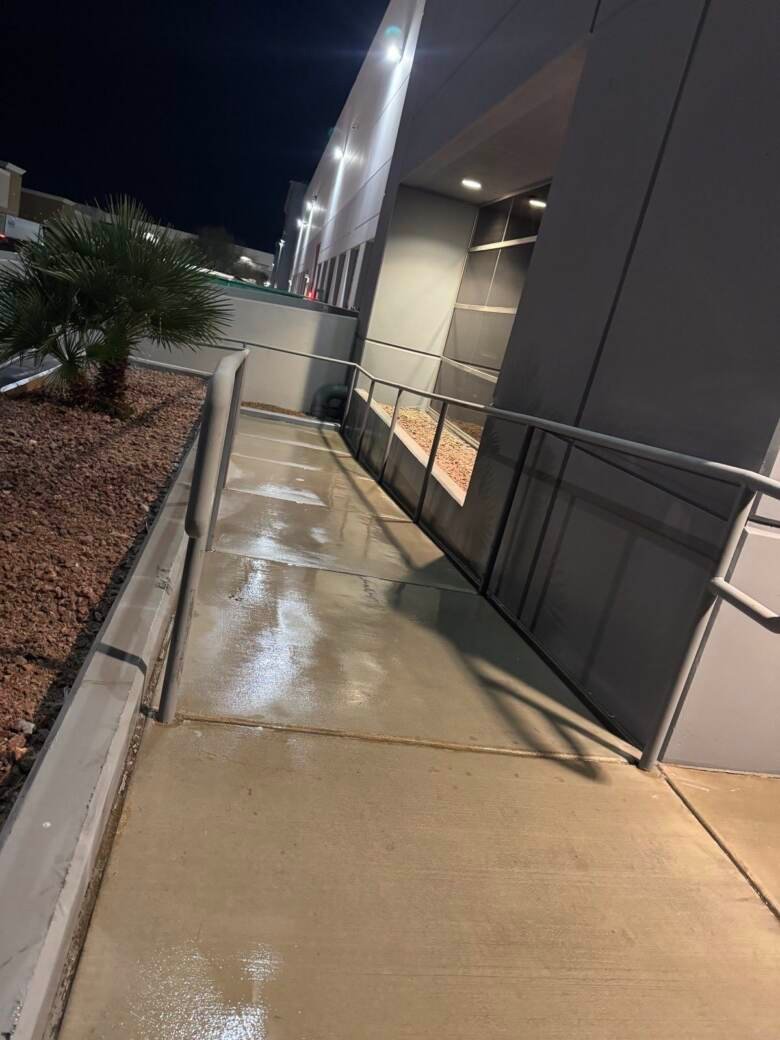 Cleaned accessible ramp and walkway alongside a commercial building at night
