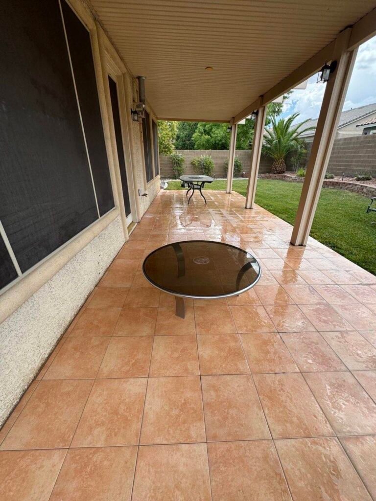 Clean tile patio under a covered patio at a Las Vegas home with lawn behind