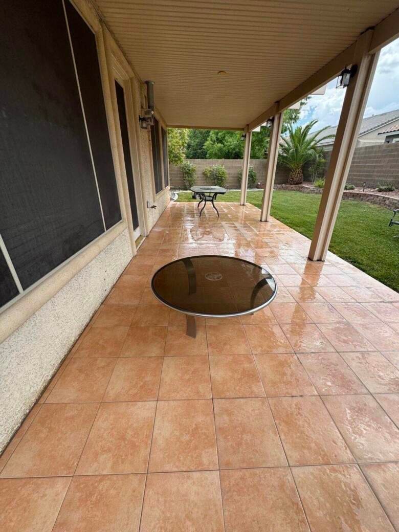 Clean tile patio under a covered patio at a Las Vegas home with lawn behind