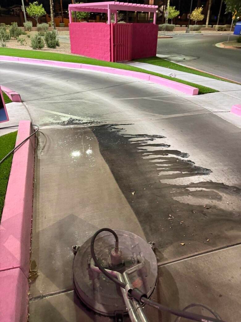 Drive-thru concrete partway through cleaning with a sharp edge between clean and soiled areas