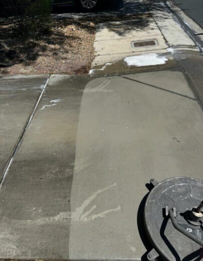 Driveway Cleaning Before After Las Vegas Driveway being cleaned, with a clear line between the washed strip and the dirty concrete beside it