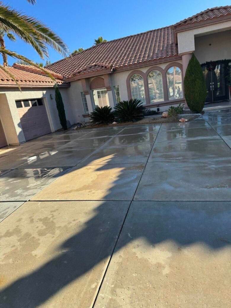 Freshly pressure washed concrete driveway at a Las Vegas home with palm trees