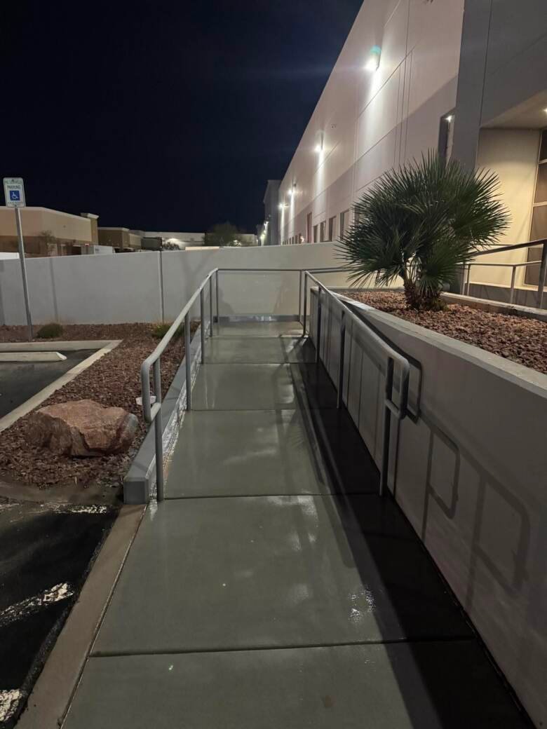 Cleaned walkway alongside an industrial building at night