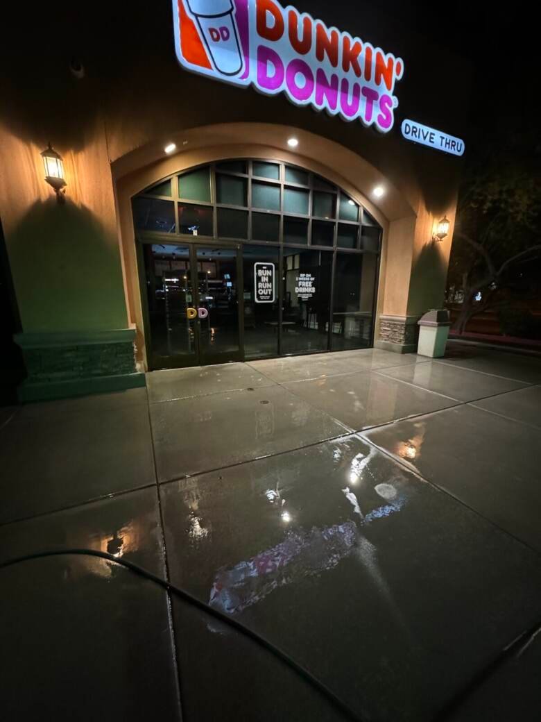 Clean wet concrete at a lit restaurant entrance at night