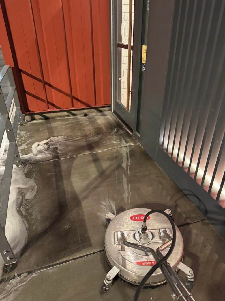 Commercial service area being cleaned at night with detergent on the concrete