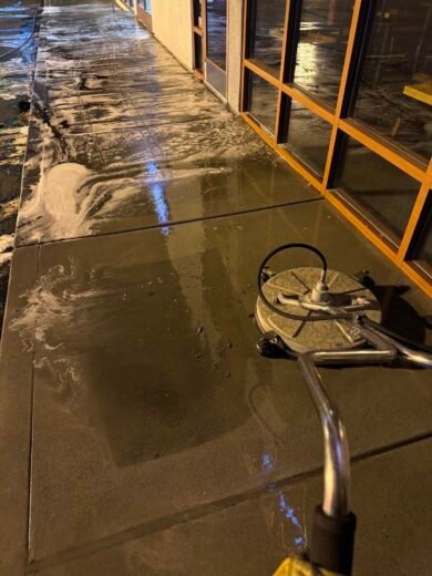 Storefront Pressure Washing Las Vegas Surface cleaner washing a lit storefront walkway at night